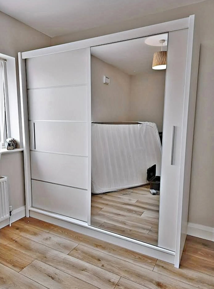 White sliding wardrobe with mirror door in a room.